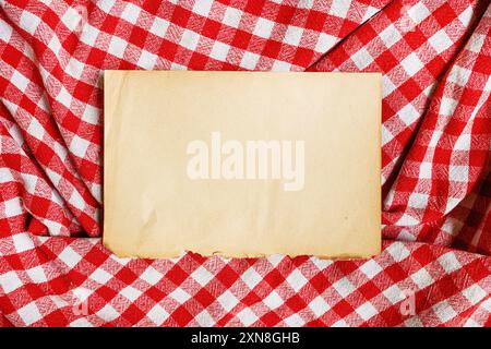 Cooking recipe mockup, old yellow worn paper on checkered table cloth, top view Stock Photo