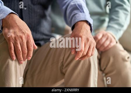 two asian senior people sitting on chairs together Stock Photo