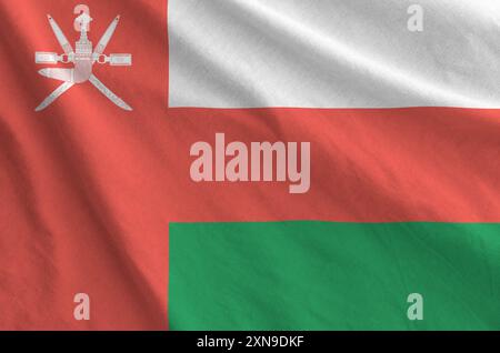 Oman flag depicted on folded wavy fabric of old cloth close up Stock Photo