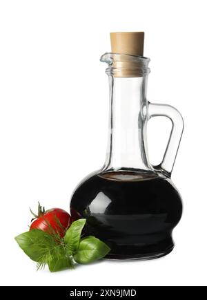 Balsamic vinegar in glass jug, herbs and tomato isolated on white Stock Photo