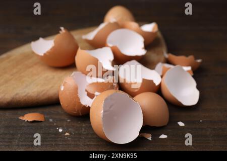 Pieces of broken eggshells on wooden table, closeup Stock Photo