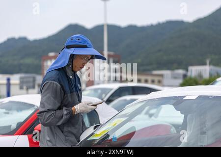 (240731) -- CHONGQING, July 31, 2024 (Xinhua) -- A staff member checks imported vehicles at the Chongqing Railway Port of Chongqing International Logistics Hub Park in Shapingba District of Chongqing, southwest China, July 30, 2024. Chongqing International Logistics Hub Park, along with its 62 freight train routes, has risen to be a major hub of international freight trains in the country's western region. As many international logistics channels converge in Chongqing, the mountainous city is leveraging its connectivity, playing a strategic fulcrum role and transforming into a crucial highl Stock Photo