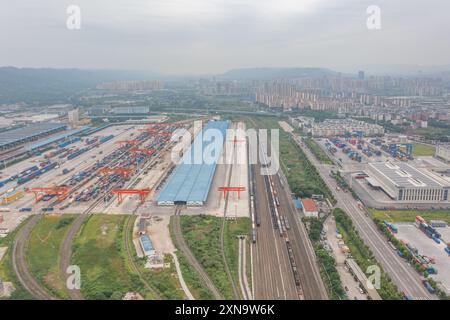 (240731) -- CHONGQING, July 31, 2024 (Xinhua) -- An aerial drone photo taken on July 30, 2024 shows the Tuanjiecun Station, Xinglongchang Station and dry port of the New International Land-Sea Trade Corridor (L-R) at the Chongqing International Logistics Hub Park in Shapingba District of Chongqing, southwest China.  Chongqing International Logistics Hub Park, along with its 62 freight train routes, has risen to be a major hub of international freight trains in the country's western region.   As many international logistics channels converge in Chongqing, the mountainous city is leveraging its Stock Photo