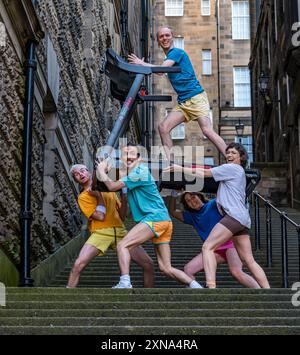 Edinburgh, Scotland, UK, 31 July 2024, Edinburgh Festival Fringe: Australian company Pony Cam make their Edinburgh Fringe debut with their show Burnout Paradise, multi-tasking on four treadmills.  The performers pose carrying treadmills up the Warriston’s Close staircase in the city’s Old Town. Credit: Sally Anderson/Alamy Live News Stock Photo