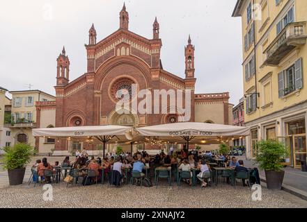 Milanese workers enjoying aperitivo in Piazza del Carmine at sunset in front of Santa Maria del Carmine Church in the Brera area of Milan, Italy Stock Photo