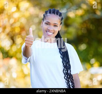 Portrait, happy and black woman with thumbs up outdoor for thank you, agreement and support of nature . Smile, African person and votes yes, opinion Stock Photo