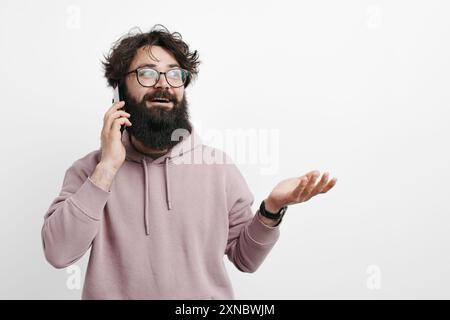 Bearded man talking on the phone with a perplexed expression Stock Photo