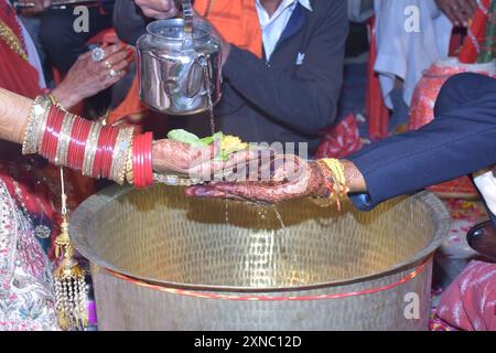 Wedding Couple Nice Hands, hindu groom and bride's hands during marriage ceremony, water eclipse ceremony Stock Photo