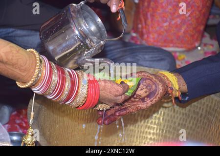 Wedding Couple Nice Hands, hindu groom and bride's hands during marriage ceremony, water eclipse ceremony Stock Photo