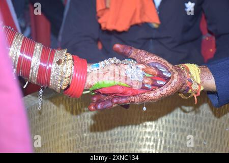 Wedding Couple Nice Hands, hindu groom and bride's hands during marriage ceremony, water eclipse ceremony Stock Photo