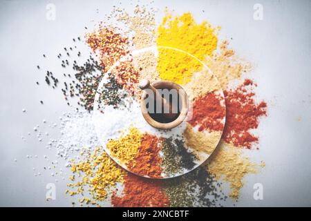 Mortar, pestle and spices in white background for collection, flavor and sensory appeal for creativity. Studio, powder and seasoning for cooking with Stock Photo