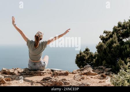 Woman Celebrating on a Clifftop with Arms Raised Stock Photo