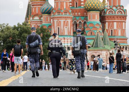 Soldiers of russian military forces of National Guard and police woman walking down the Red Square on background of St Basil Cathedral Stock Photo