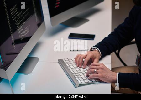 Minimal high angle closeup of unrecognizable man typing on keyboard and using computer while working at desk copy space Stock Photo