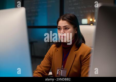 Portrait of young woman as female computer programmer looking at screen while working in cybersecurity department copy space Stock Photo