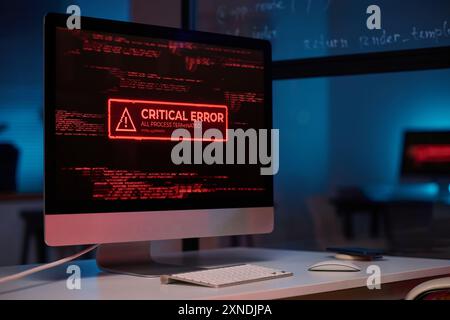 Background image of PC computer with emergency message of critical error on screen in red lights copy space Stock Photo
