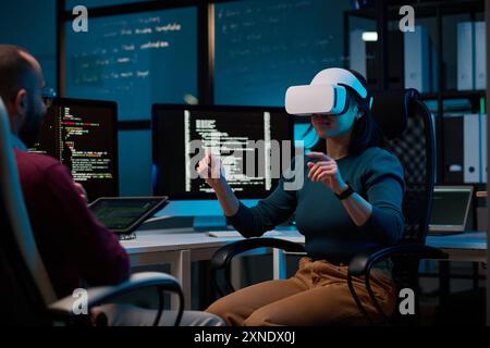 Portrait of young woman wearing VR headset in IT innovation department with code lines in background copy space Stock Photo