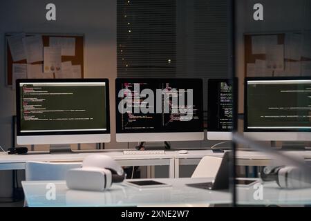 Background image of three computer screens with code lines cybersecurity office, copy space Stock Photo