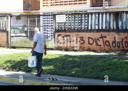 Valencia, Carabobo, Venezuela. 31st July, 2024. July 31, 2024. A man walks in front of a graffiti protesting against the election results of the presidential election. It reads 'this is dictatorship'', in the city of Valencia, Carabobo state. Photo: Juan Carlos HernÃndez (Credit Image: © Juan Carlos Hernandez/ZUMA Press Wire) EDITORIAL USAGE ONLY! Not for Commercial USAGE! Stock Photo