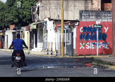 Valencia, Carabobo, Venezuela. 31st July, 2024. July 31, 2024. A motorcyclist rides in front of graffiti scratched during protests against the results of the presidential election, in the city of Valencia, Carabobo state. Photo: Juan Carlos HernÃndez (Credit Image: © Juan Carlos Hernandez/ZUMA Press Wire) EDITORIAL USAGE ONLY! Not for Commercial USAGE! Stock Photo