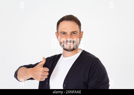 Young handsome man wearing in casual clothes doing happy thumbs up gesture with hand. Approving expression looking at the camera showing success. Stock Photo