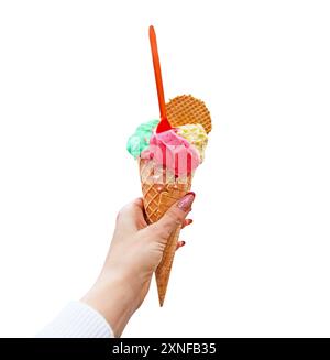 Woman's hand holding waffle cone with strawberry, pistachio and vanilla ice cream on white background. Ice cream cone on a white background. Stock Photo