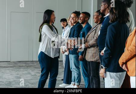 Diverse business professionals networking and shaking hands during a conference event, fostering collaboration and connection among colleagues. Stock Photo
