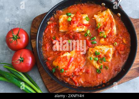 Baked cod fish in tomato and pepper sauce Stock Photo