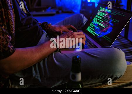 Unrecognizable male hands typing code on black keyboard with neon rays Stock Photo
