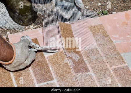 Thin fake bricks made of acrylic marble chips are reinforced with plastic mesh that can be easily cut with scissors. Stock Photo
