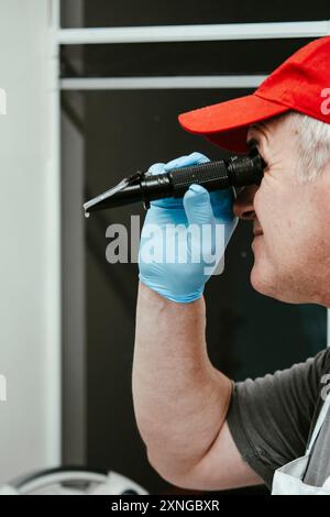 Food scientist in a lab coat and gloves uses a refractometer in a laboratory to check food quality Stock Photo
