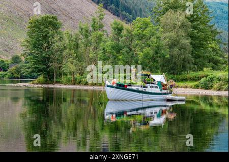 Invergarry, Highlands, Scotland, UK. 31st July, 2024. A flowery boat on a fine day at Loch Oich in the Highlands of Scotland in the Great Glen near Invergarry. Credit: John Eveson/Alamy Live News Stock Photo