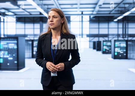 System administrator in data center identifying and solving technical issues related to data center infrastructure. IT expert managing, maintaining and securing high tech server hub environment Stock Photo