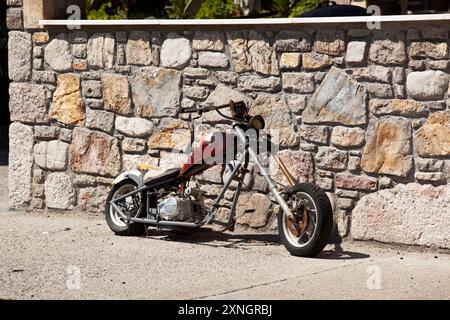 Decorative vintage motorbike against a brick grey wall on a sunny day. Horizontal. Photo in high quality Stock Photo