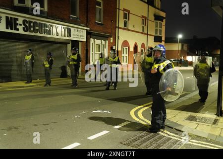 Police officers on the streets of Hartlepool following a violent protest. Videos on social media show a crowd of people in a street, with one showing a youth throwing objects at a line of police in riot gear holding shields. It comes after similar disorder in Merseyside and Whitehall, London after the mass stabbing in Southport that claimed the lives of three girls and left eight more children and two adults injured. Picture date: Wednesday July 31, 2024. Stock Photo