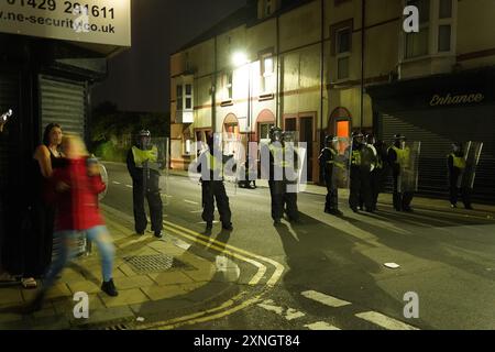 Police officers on the streets of Hartlepool following a violent protest. Videos on social media show a crowd of people in a street, with one showing a youth throwing objects at a line of police in riot gear holding shields. It comes after similar disorder in Merseyside and Whitehall, London after the mass stabbing in Southport that claimed the lives of three girls and left eight more children and two adults injured. Picture date: Wednesday July 31, 2024. Stock Photo