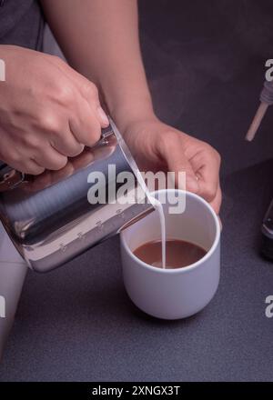Woman Barista operates a machine to prepare delicious coffee, Close-up of hands using the coffee machine preparing an espresso coffee. Stock Photo