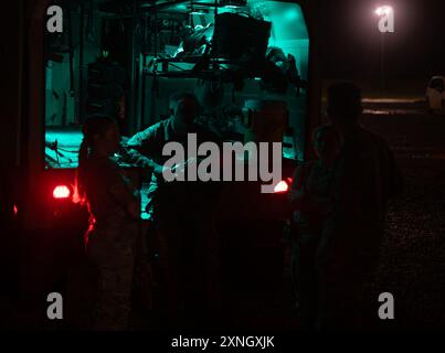Medics with the 129th Medical Company Area Support (MCAS), hang out in the back of a military ambulance during early morning hours while waiting to be called to provide transport for simulated casualties, Camp Shelby, July 26, 2024. The MCAS is trained in providing medical service ranging from basic Sick Call all the way to traumatic injuries sustained  from training or combat. (U.S. Army National Guard photo by Staff Sgt. Jaccob Hearn) Stock Photo