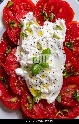 Italian cuisine. Mozzarella, heirloom tomatoes, basil leaves on a ...