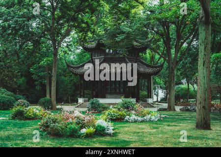 A traditional Chinese garden pavilion surrounded by lush greenery in Suzhou, China. Stock Photo