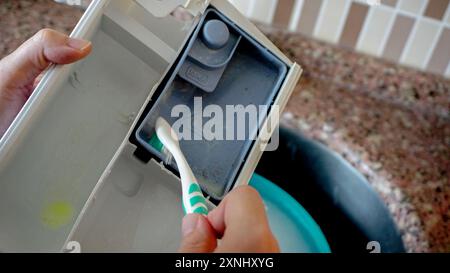 Woman cleaning detergent tray of washing machine close up view Stock Photo