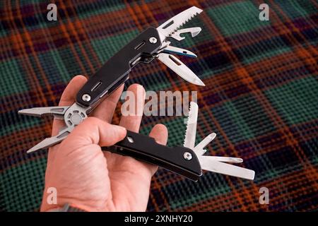 Man holding multi tool in hand close up view Stock Photo