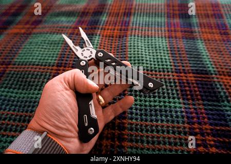 Man holding multi tool in hand close up view Stock Photo