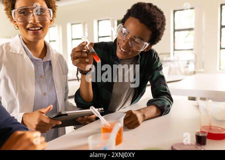 In high school, students conducting science experiment with test tubes and safety goggles Stock Photo