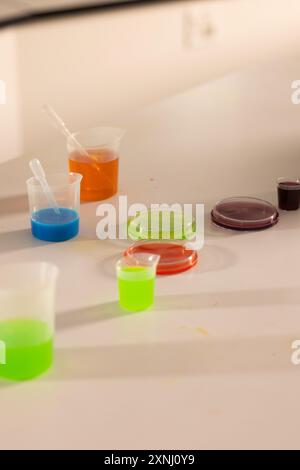 Science experiment in high school, colorful liquids in beakers on laboratory table Stock Photo
