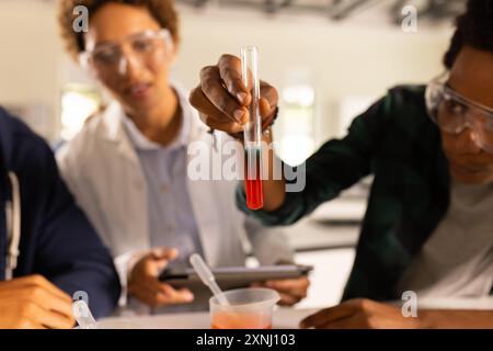 In high school, students conducting science experiment with test tube and pipette Stock Photo