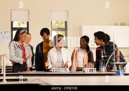 In high school laboratory, students listening to teacher explaining science experiment Stock Photo