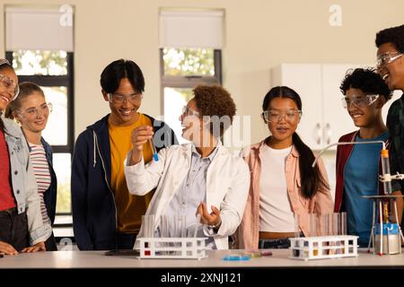 Wearing safety goggles, students conducting science experiment in high school classroom Stock Photo