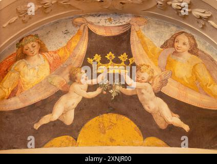 SPELLO, ITALY - MAY 18, 2024: The fresco of angels wtih the crown in the church Collegiata di San Lorenzo by unknown artist Stock Photo