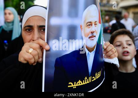 Sidon, Lebanon. 31st July, 2024. A woman attends a gathering denouncing the assassination of Hamas leader Ismail Haniyeh in Sidon, Lebanon, on July 31, 2024. Hezbollah on Wednesday offered its condolences for the death of Hamas Politburo Chief Ismail Haniyeh, while Lebanon's prime minister condemned the killing as a grave danger. On the same day, a gathering took place in the southern Lebanese city of Sidon, where people protested against the assassination of Haniyeh. Credit: Ali Hashisho/Xinhua/Alamy Live News Stock Photo